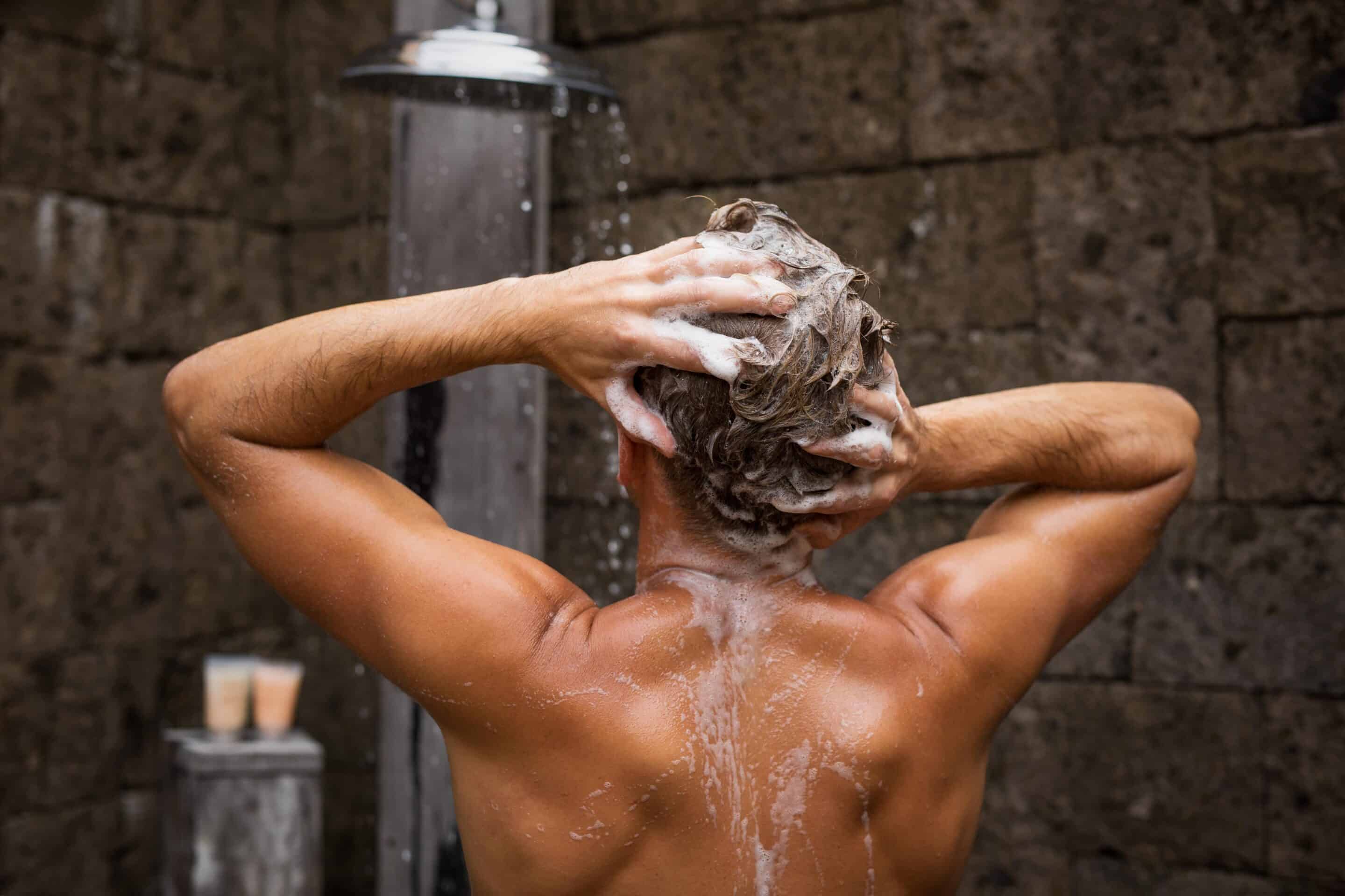 Ein Mann unter der Dusche wäscht seine Haare