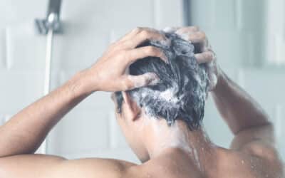 Ein Mann wäscht sich die Haare mit Ketozolin Schampoo unter der Dusche